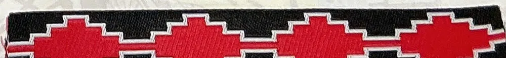 Woven tape with a repeating red and black geometric pattern
